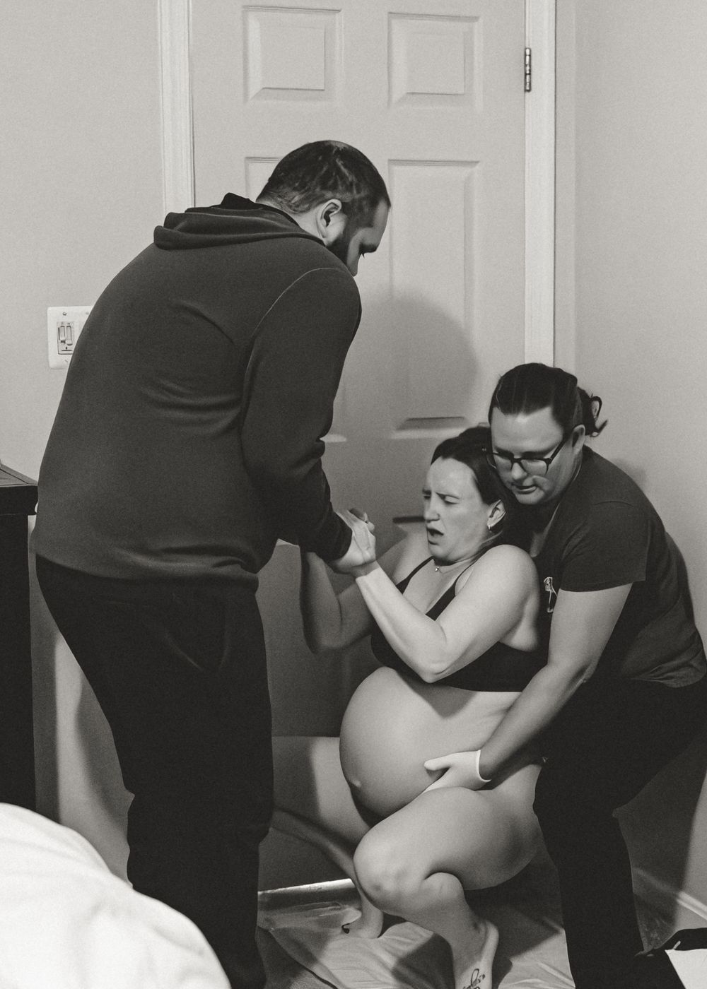 Black and white photo sequence showing a person helping another person in labor during a home birth.