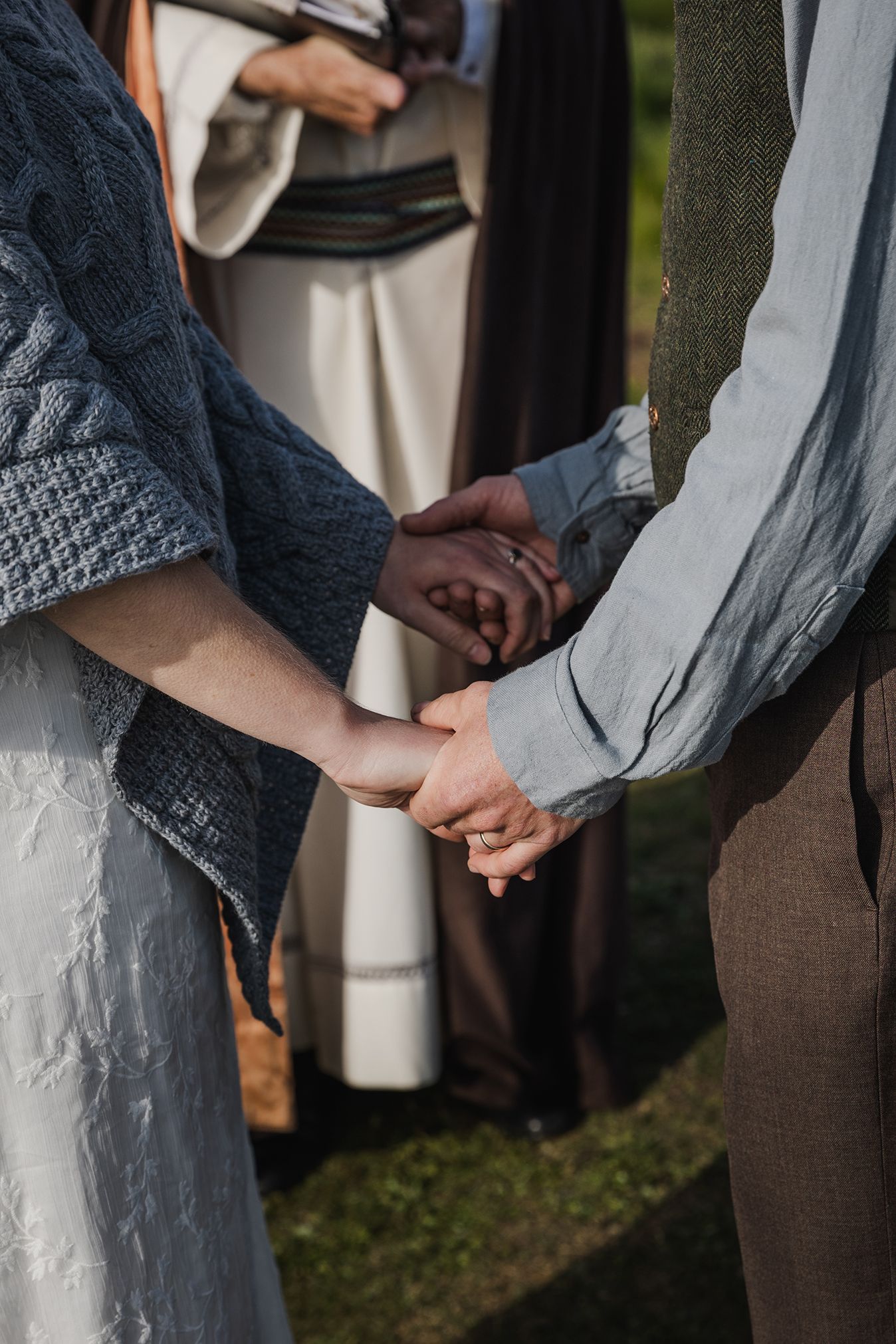 close up of couple holding hands during sunset elopement at Hags Head Cliffs of Moher