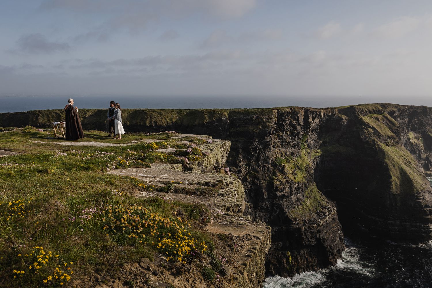 Couple exchanging vows during sunset elopement at Hags Head Cliffs of Moher with seapinks in bloom