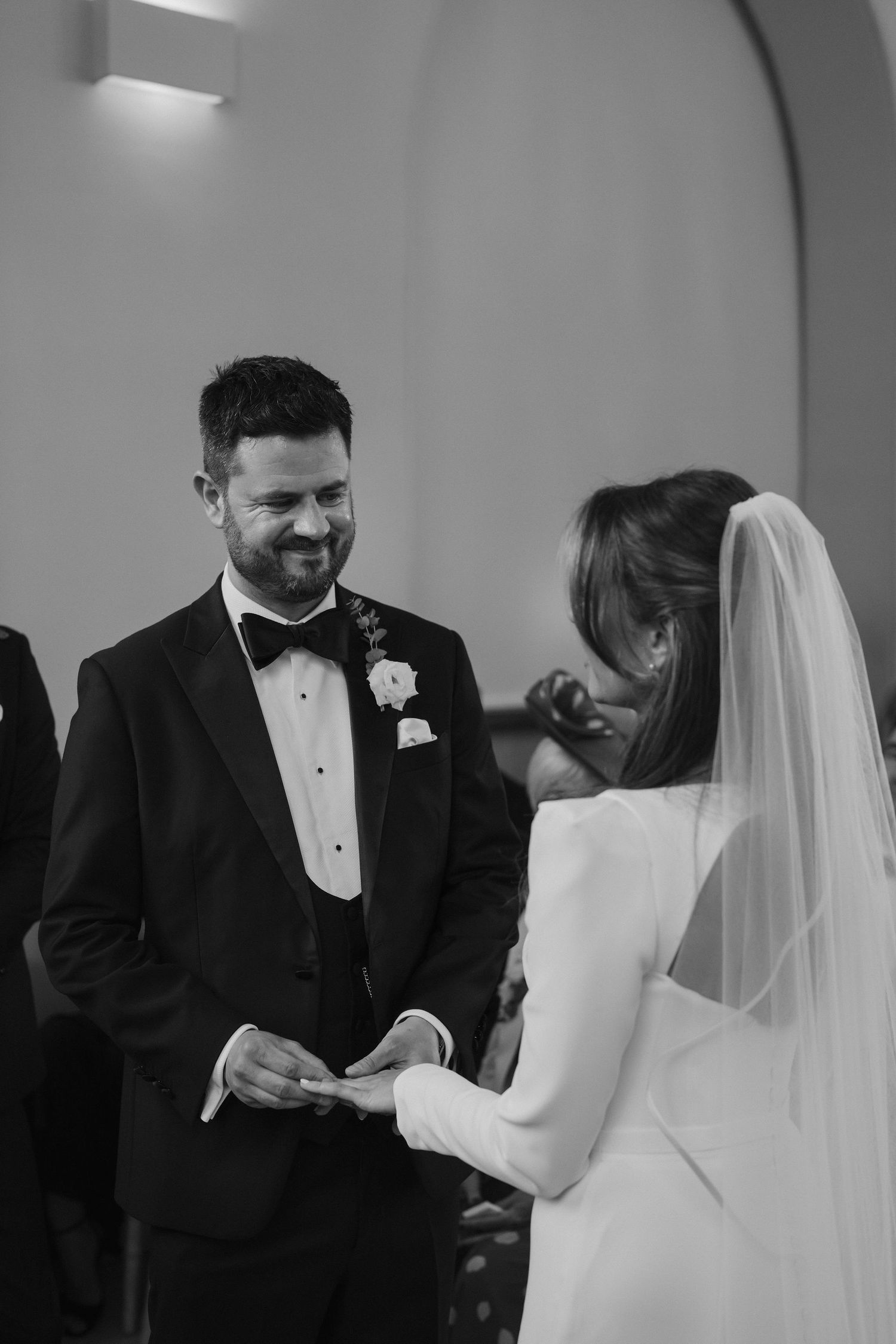 groom placing the ring on the brides finger during exchanging of rings at Iscoyd park