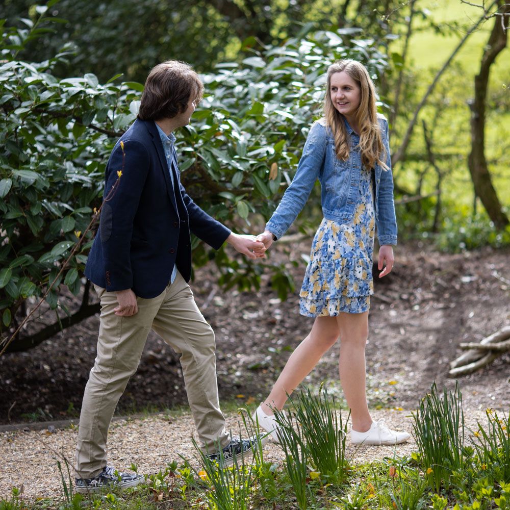 Young woman leads her fiancé in garden of Kent grand house