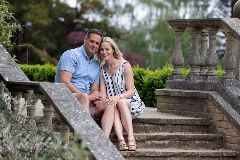 Couple sit on steps of grand historic house garden