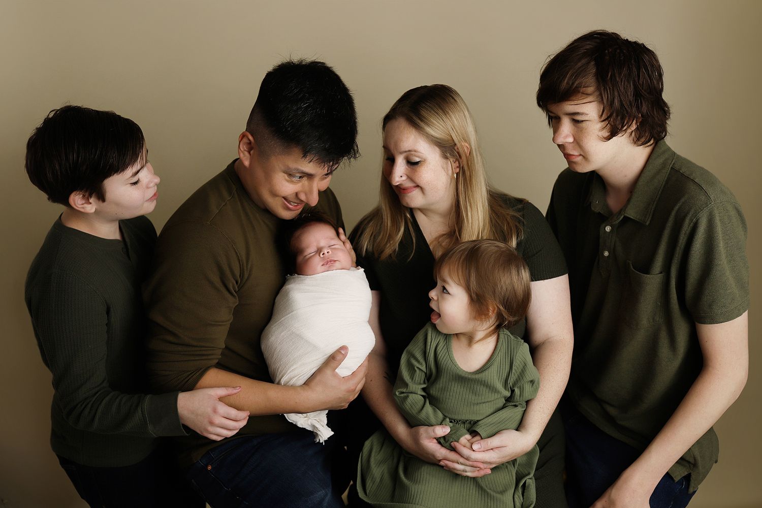 A series of intimate family portraits showing tender moments between parents and children in muted tones. utah newborn photos