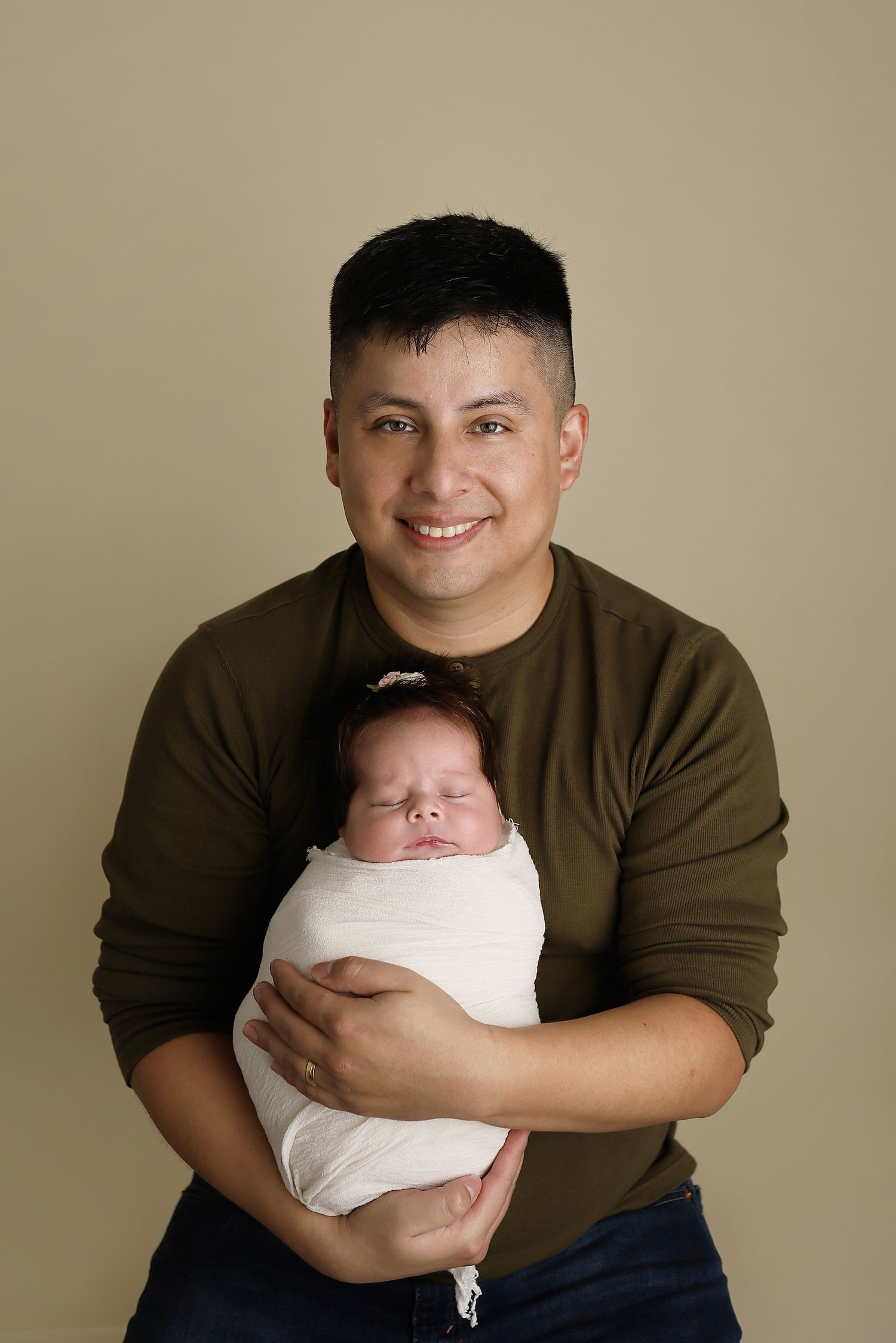 A series of five progressive photos showing someone in a brown sweater holding and smiling with a swaddled newborn baby. utah newborn photos