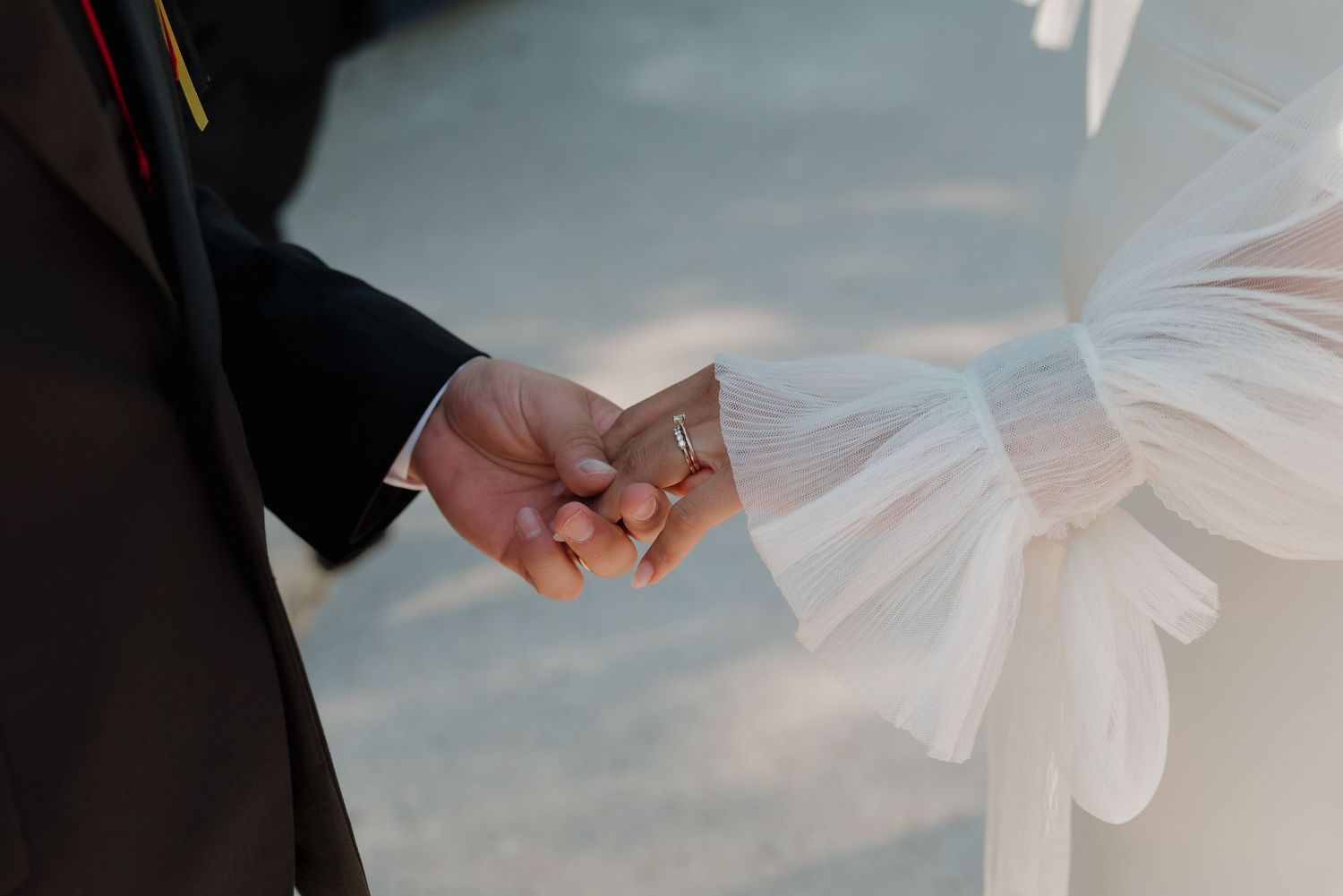 Wedding couple holding hands during lakeside ceremony with soft lighting.