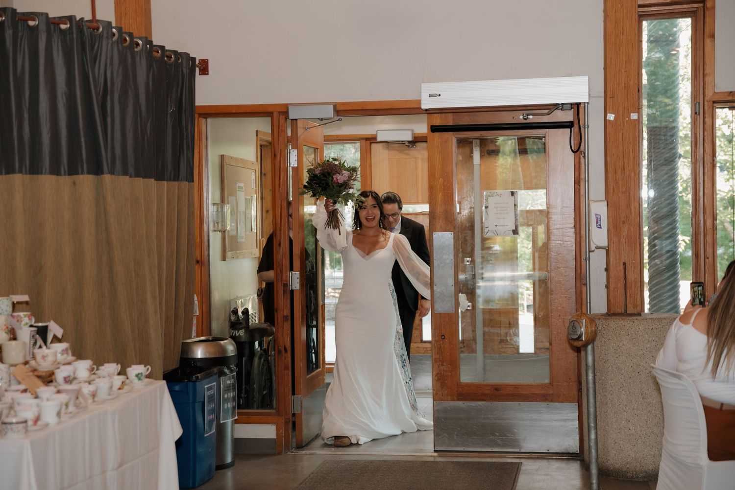 Wedding venue interior with natural light streaming through large windows and elegant white decor.
