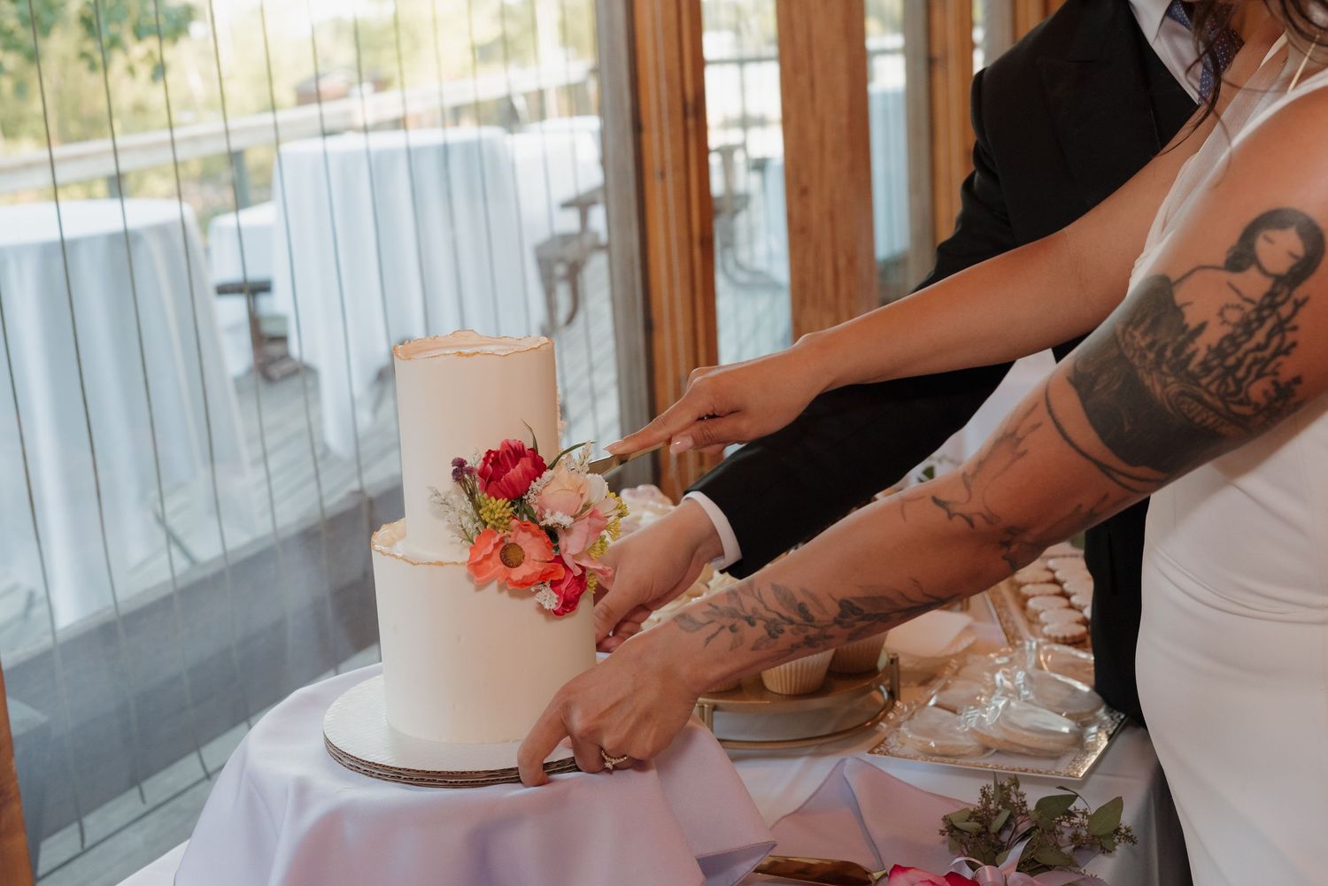 Close-up of hands arranging pink rose petals on a white surface during event preparation.