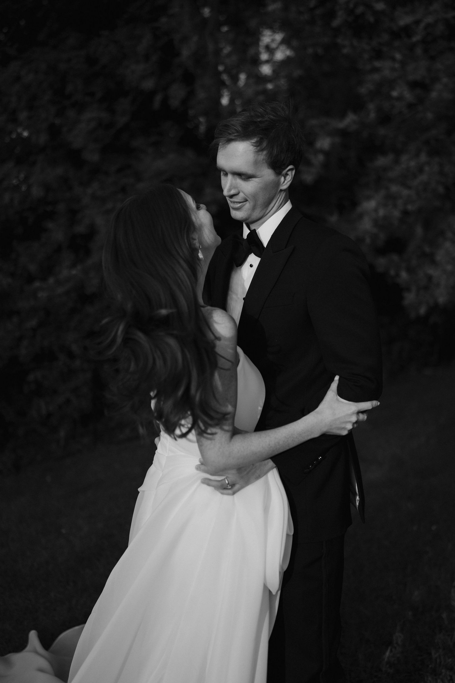 groom squeezing bride in while smiling at her at dewsall court in herefordshire