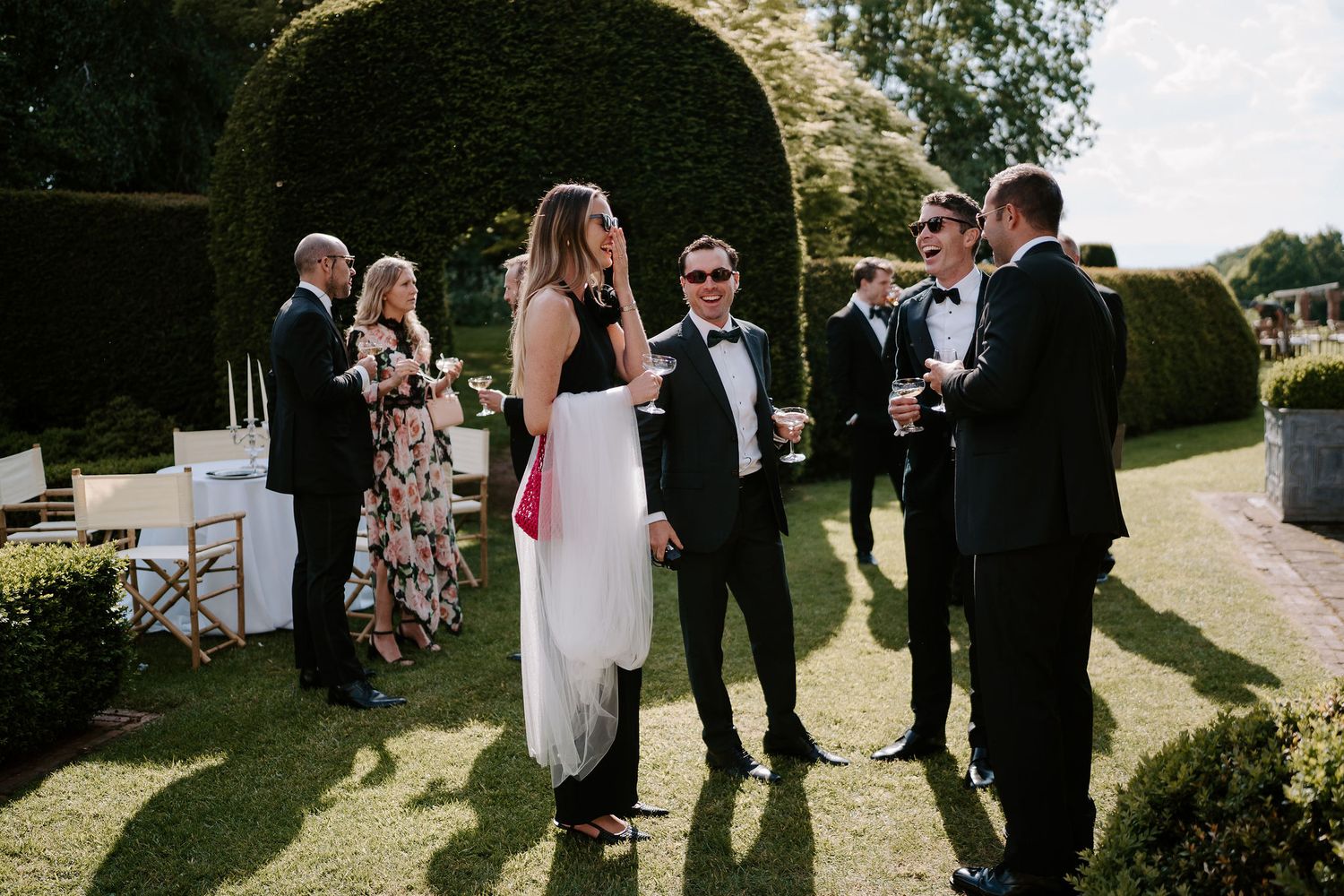 wedding guests laughing with glasses of champagne in their hands at dewsall court in herefordshire