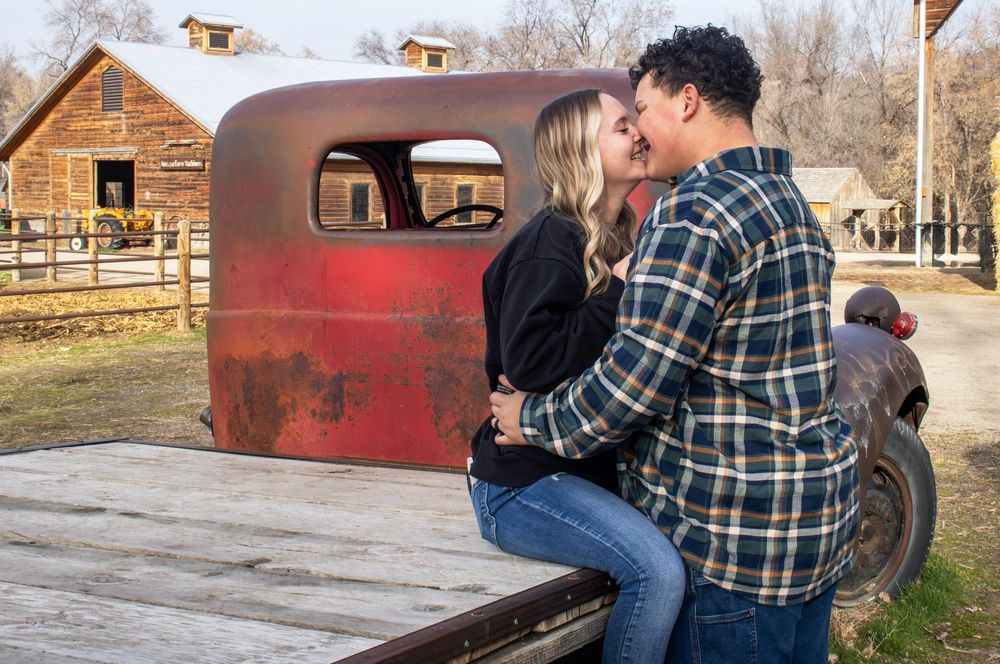 Couple kissing by a vintage truck during an outdoor engagement session in Utah