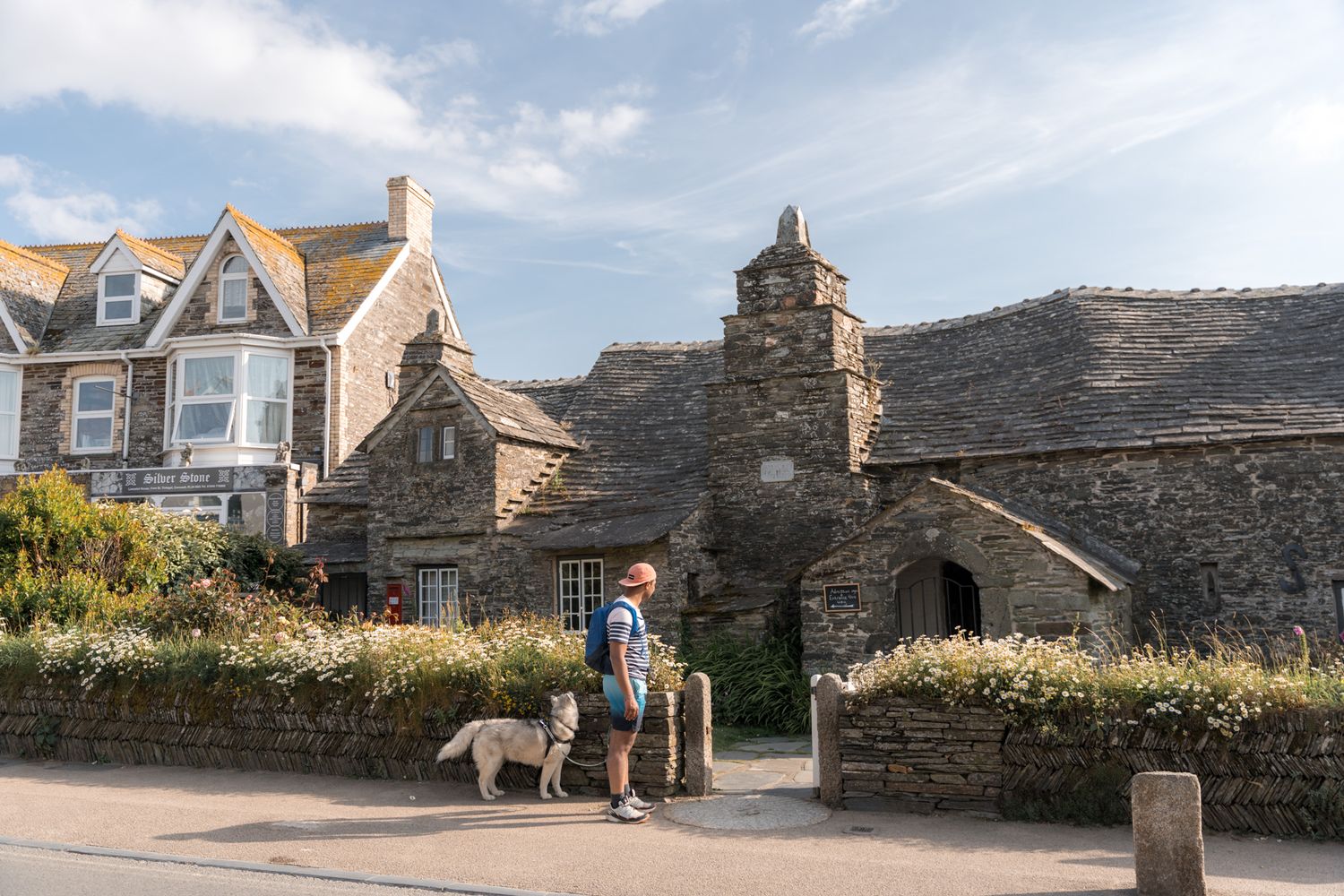 randonneur et son chien devant la poste de tintagel dans les cornouailles en angleterre