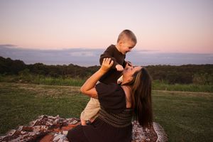 Newcastle motherhood photographer captured a mother playing with her toddler at a lookout in golden hour light