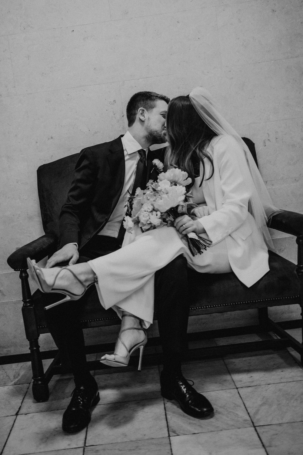 A sequence of black and white photos showing a couple in wedding attire lying on the ground in artistic poses.