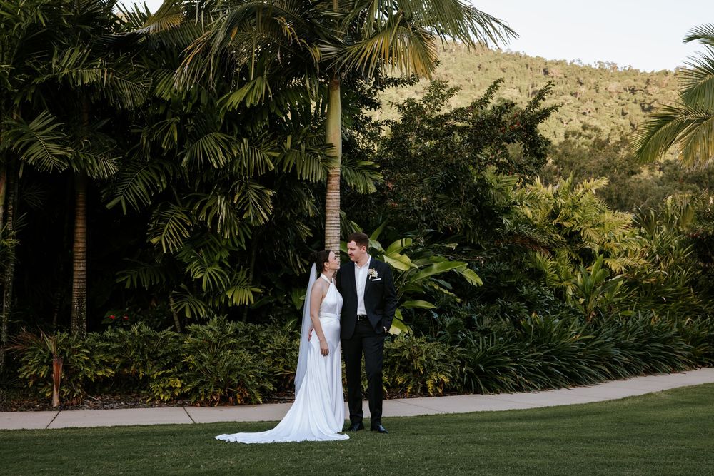 Couple walking together on a garden path surrounded by lush tropical landscaping.