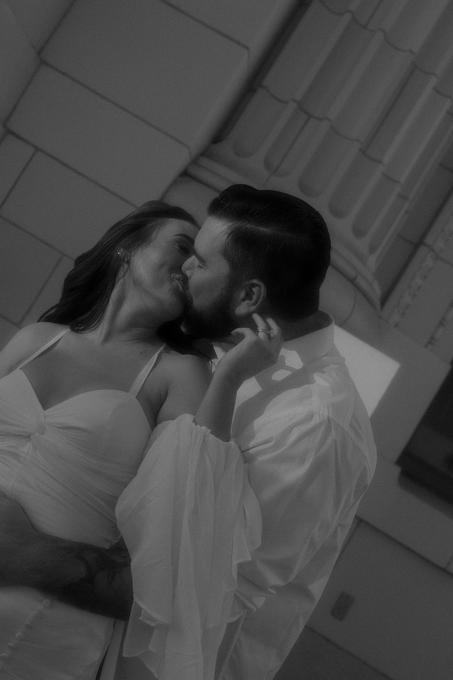 A black and white photo sequence shows a romantic kiss between two people in white clothing.
