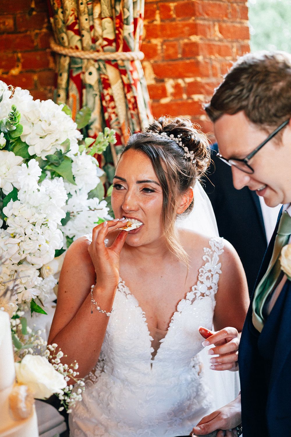 A sequence of candid wedding photos showing joyful moments with white floral decorations against a rustic brick wall.