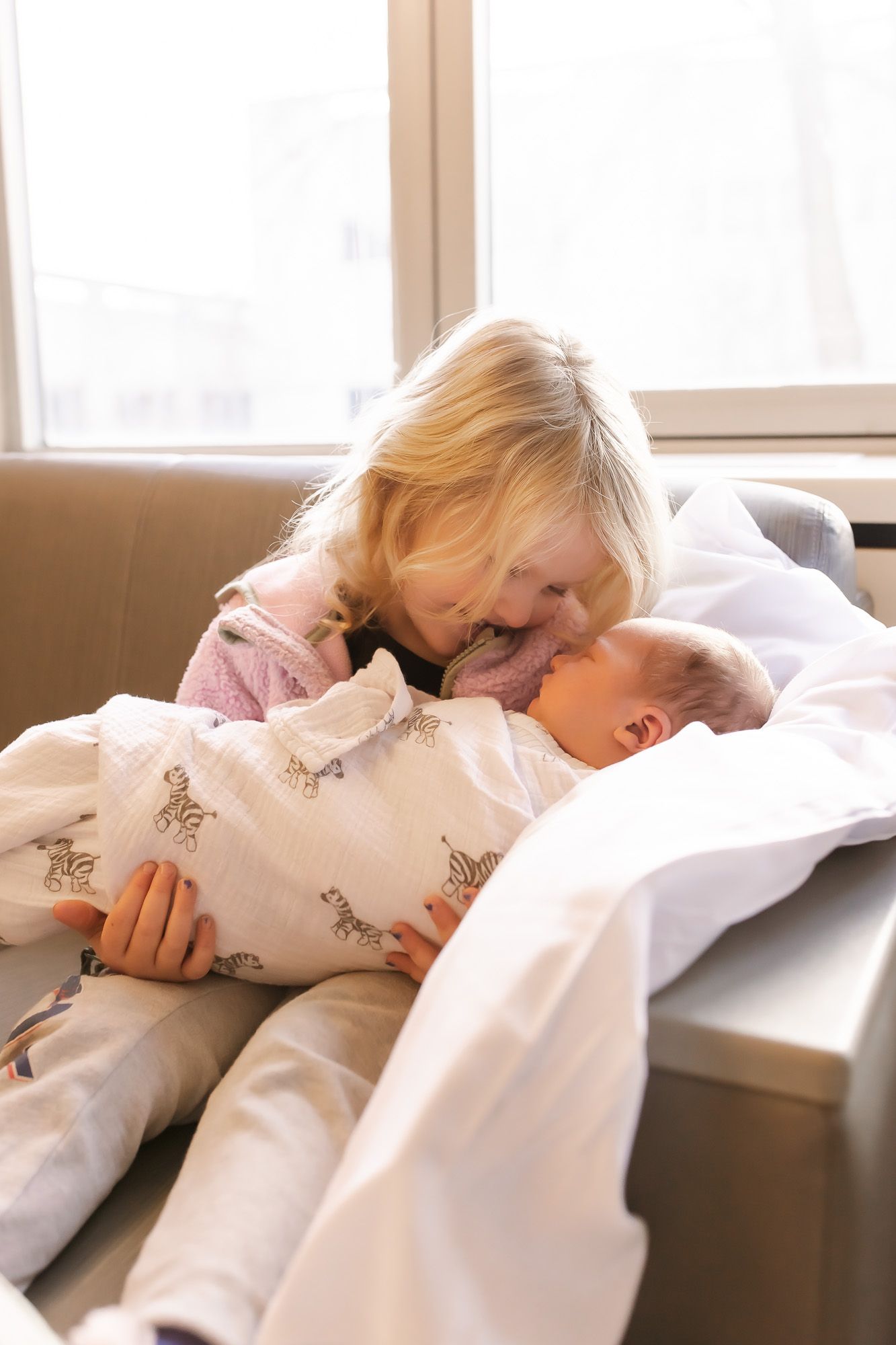 Big sister holding brother for the first time during a Fresh 48 session in Wausau, Wisconsin.