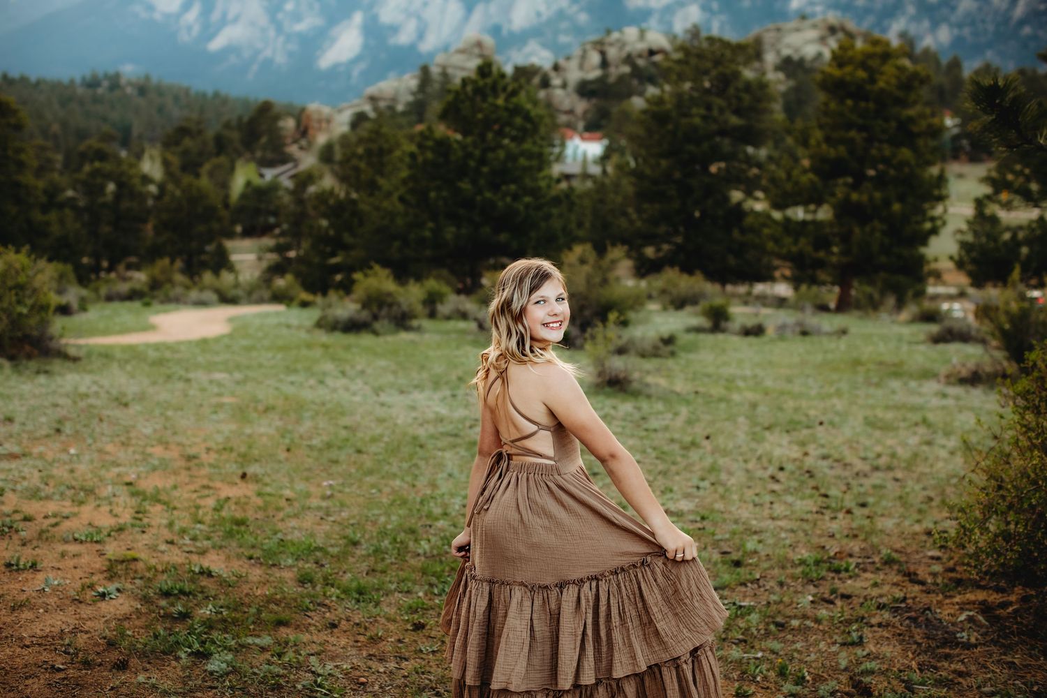 A flowing brown dress twirls gracefully against a mountain backdrop in Colorado.