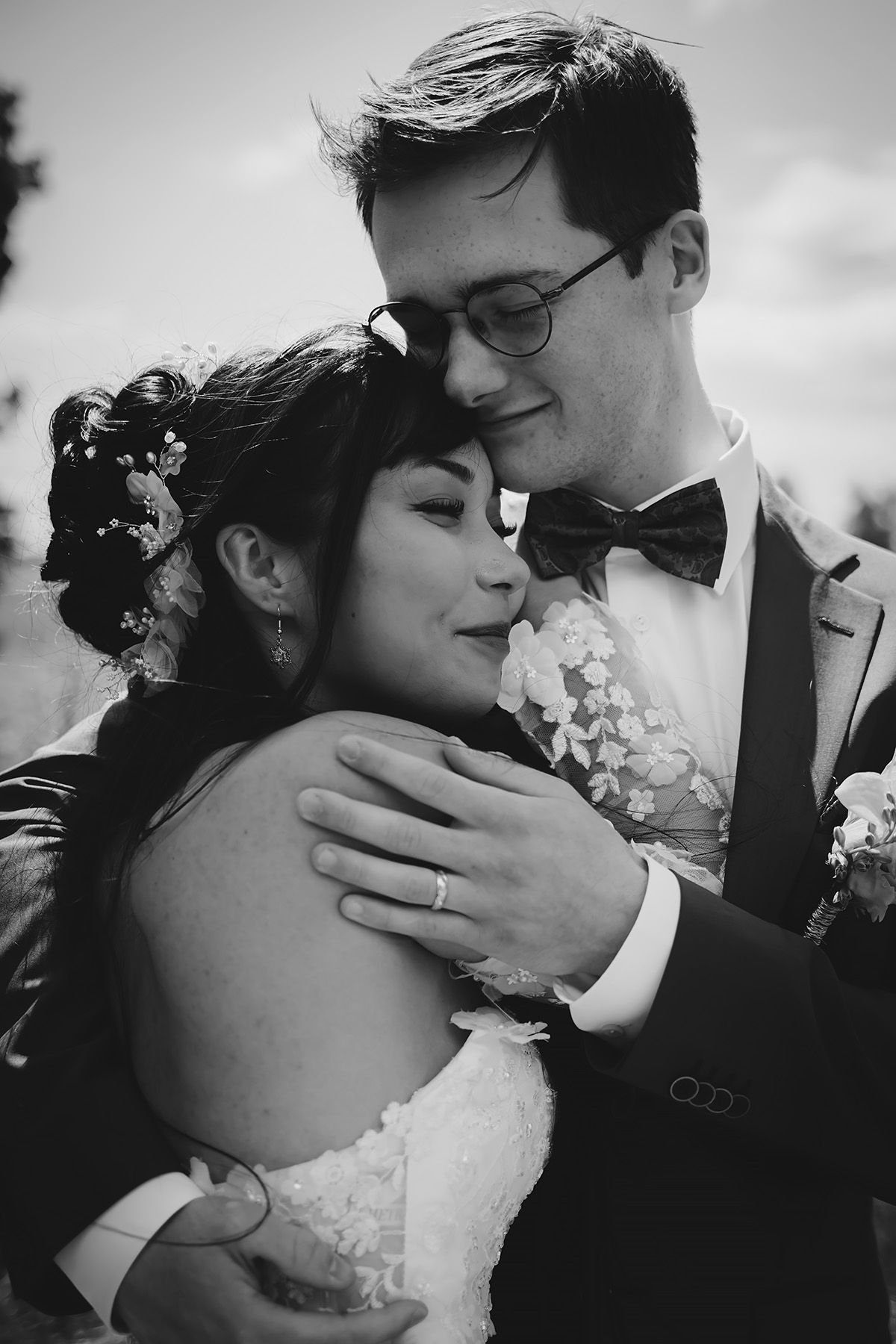 Nära porträtt på brudpar som håller om varandra i en hård omfamning, foto av Josefin Landhagen bröllopsfotograf i Vadstena och Östergötland.