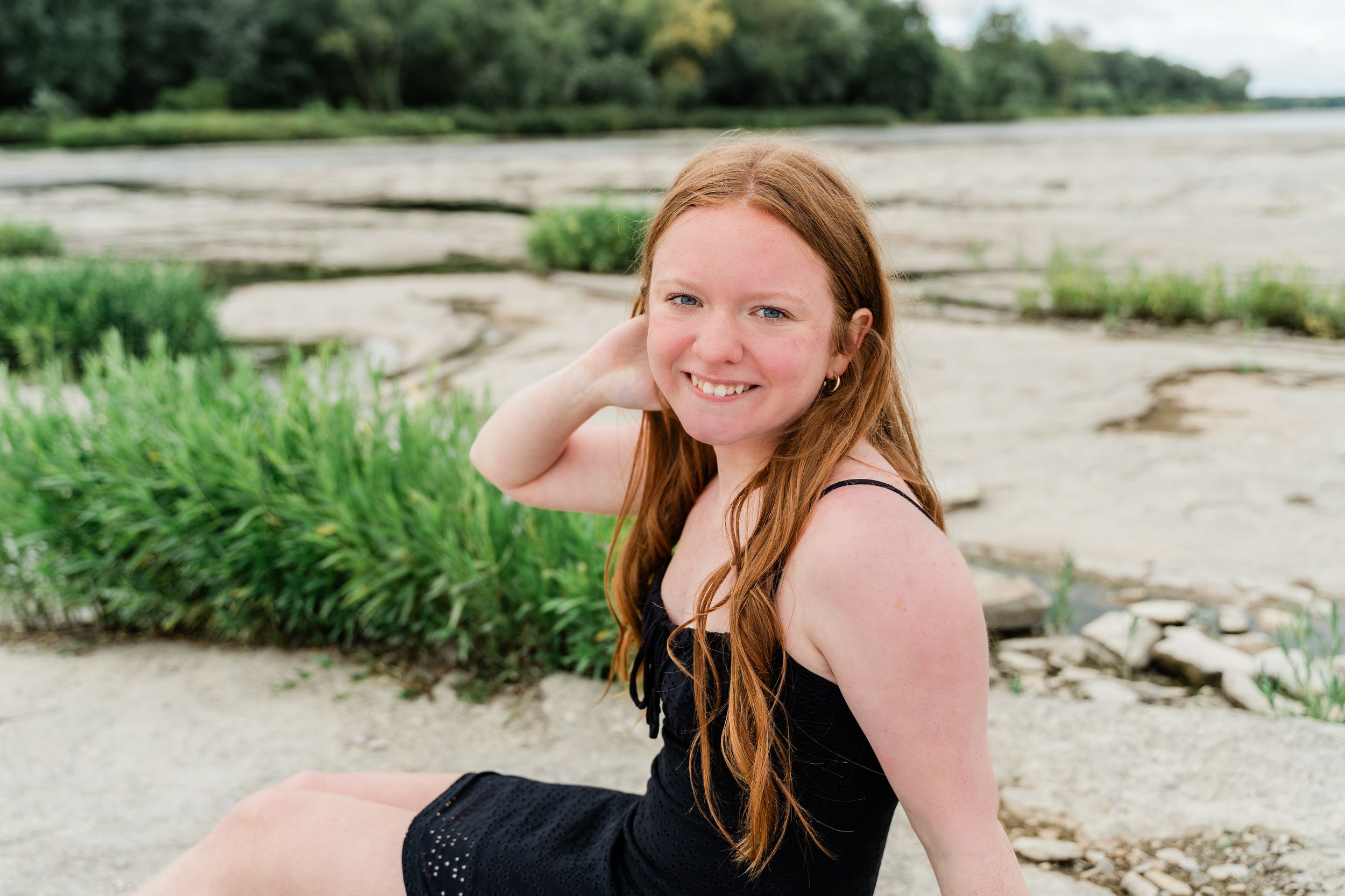 A series of five beach portraits showing someone in casual summer attire posing along a rocky shoreline.