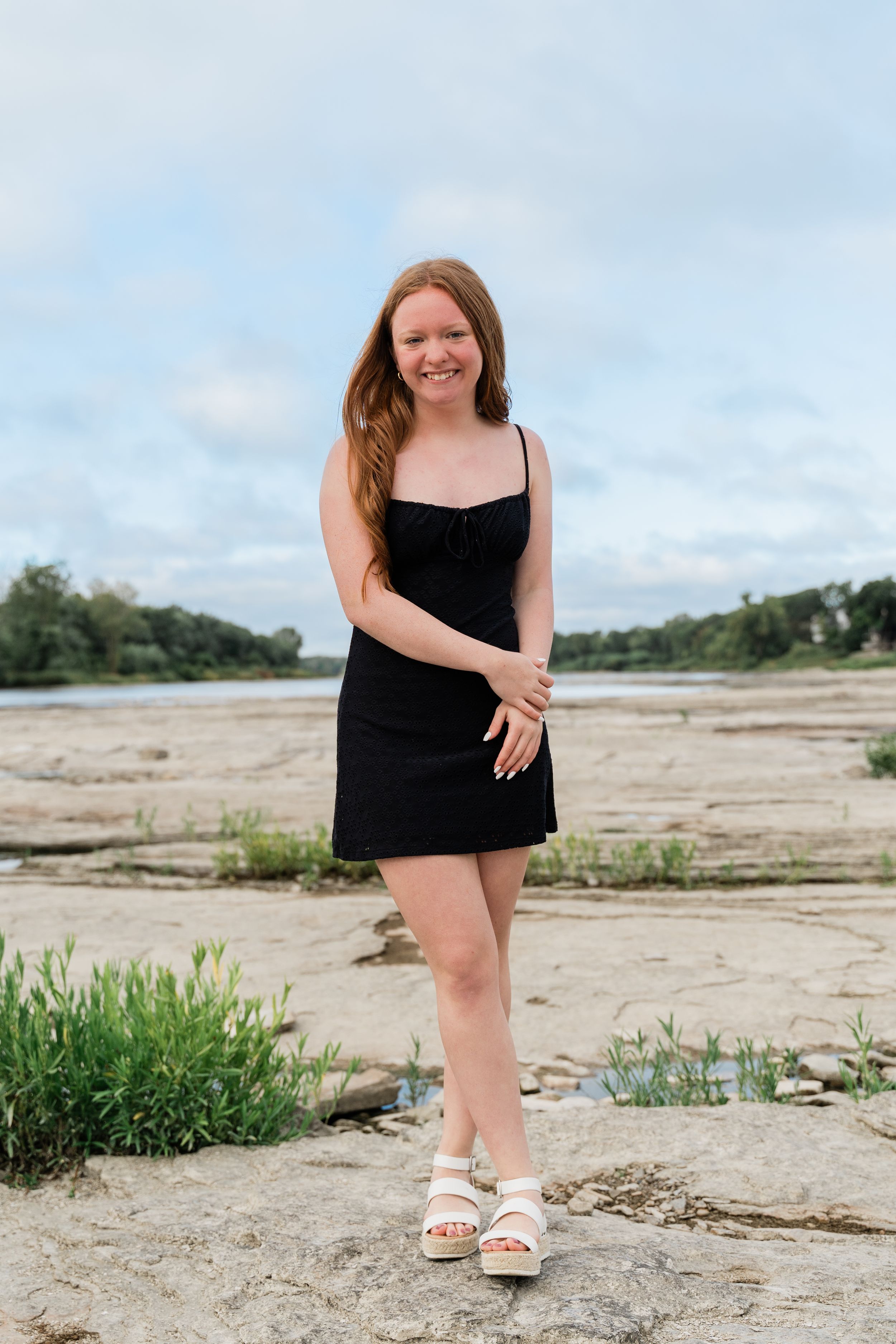 A series of photos showing someone in a black dress posing on a sandy beach area with vegetation in the background.