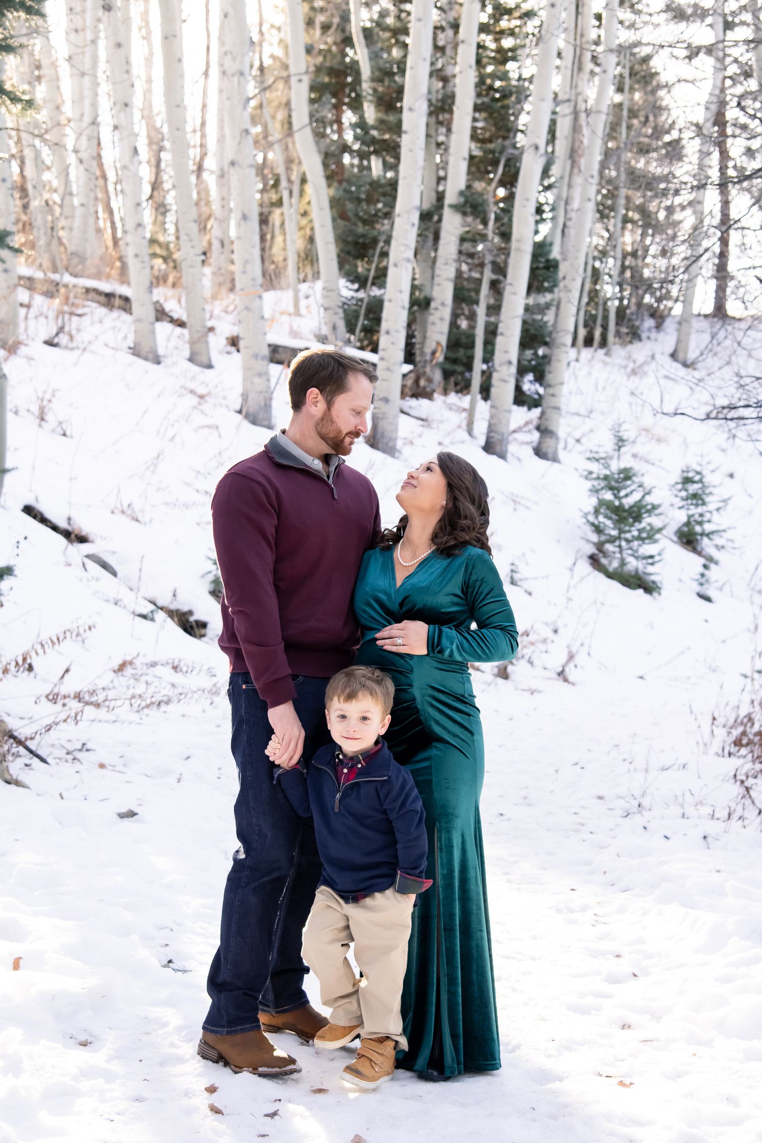 Family shares joyful moments together in a snowy aspen forest during winter photoshoot in Aspen Colorado