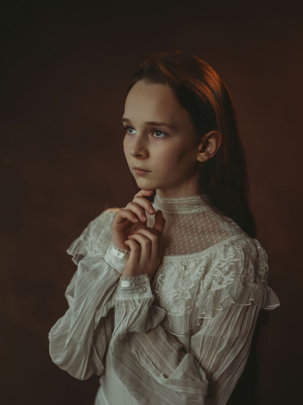 A series of moody portraits featuring someone in a vintage-style white ruffled blouse against a dark background.