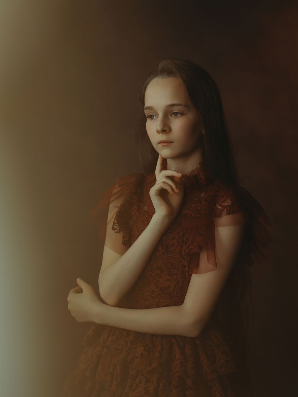A series of four moody, sepia-toned portraits showing a person in a rust-colored dress against a dark background.