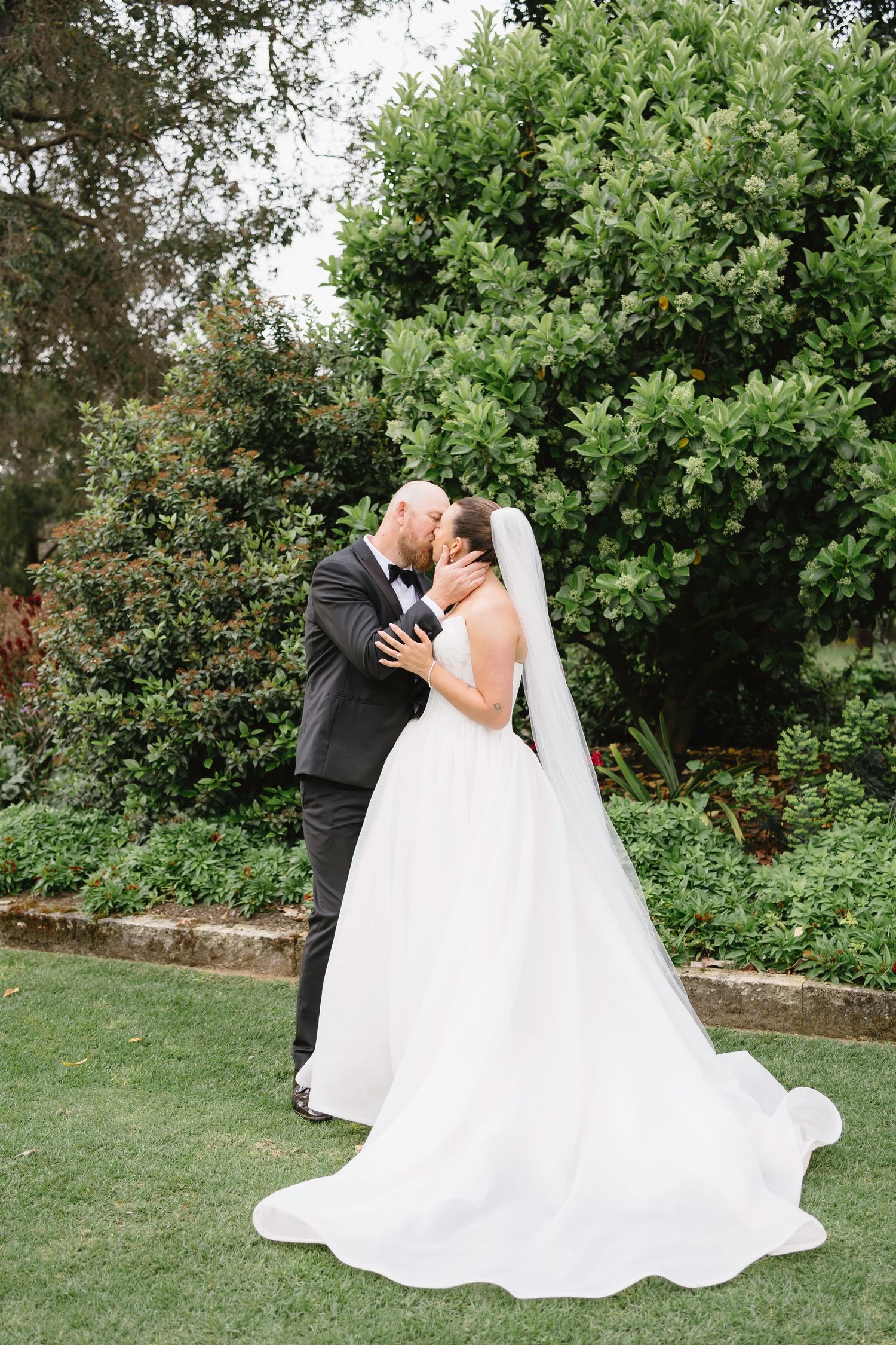 Black and white wedding photo details showing the bride's lace dress bodice and groom's light colored suit.