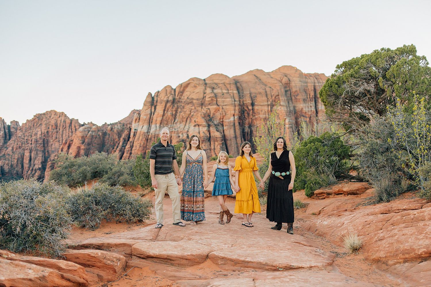 A series of landscape photos showing people in colorful outfits against red rock formations in a desert setting.