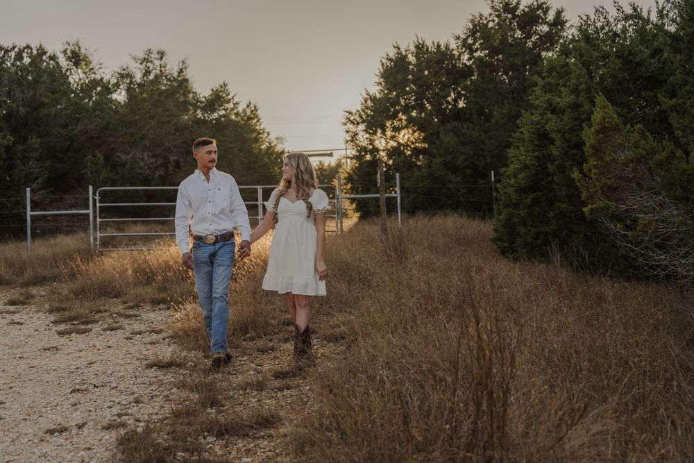 A couple walks together through a rustic outdoor setting during golden hour sunset.