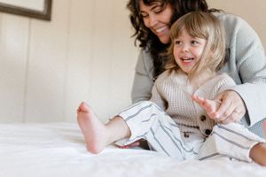 A series of candid photos showing tender moments between a parent and child reading together in bed.