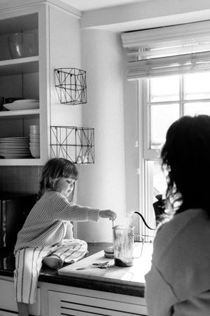 A series of black and white photos showing people relaxing by a bright window.