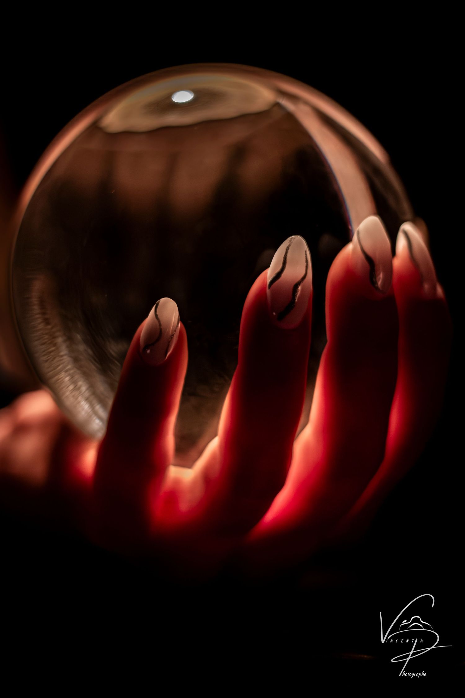 Carved pumpkin lantern glowing with eerie red light in dark setting.