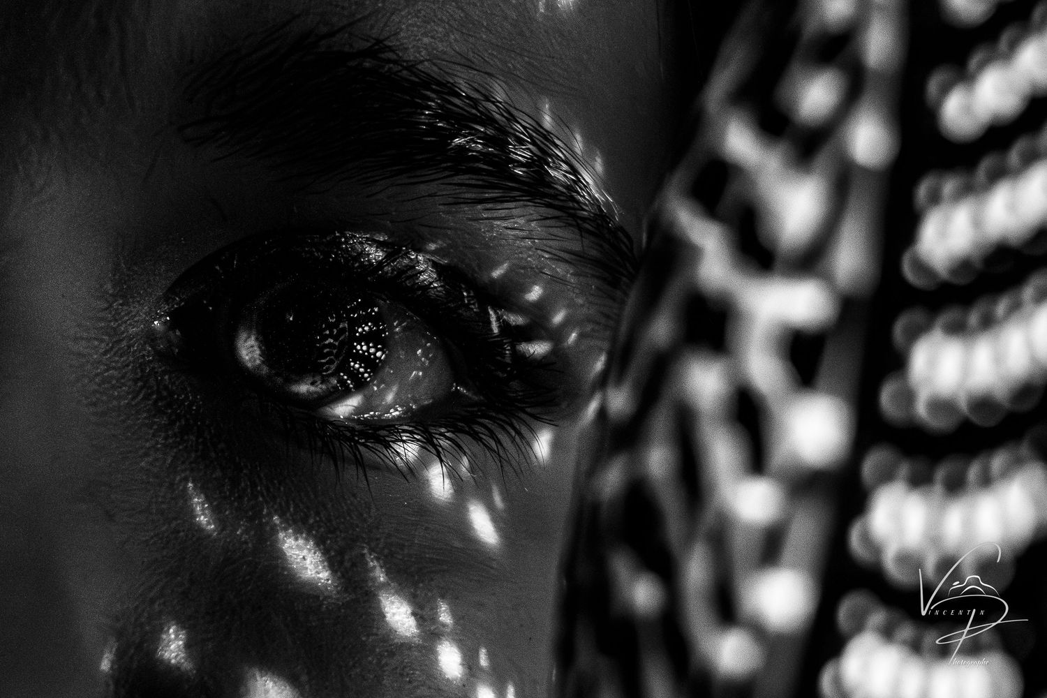 Delicate light patterns cast shadows on a dark surface creating an ethereal effect.