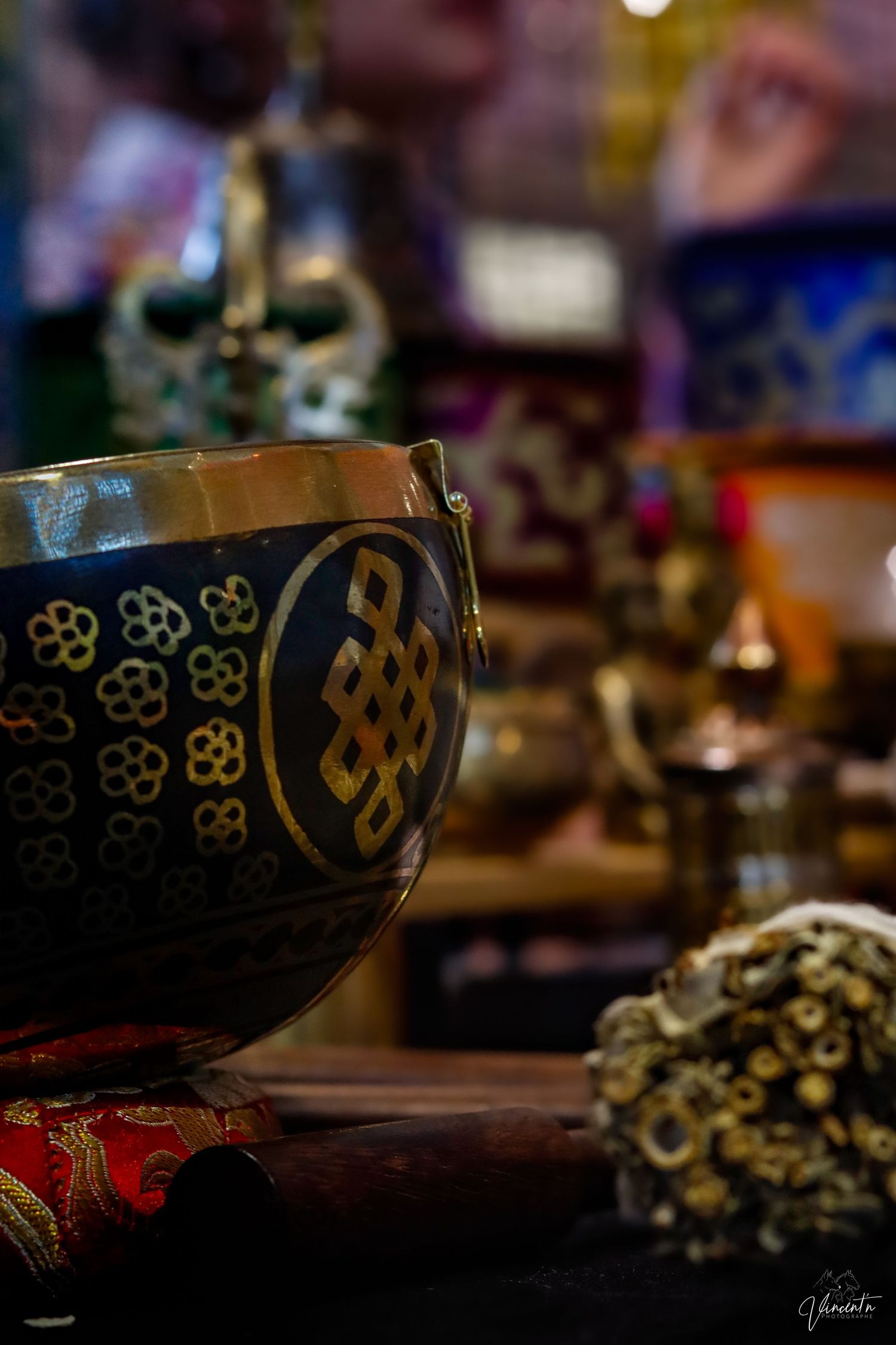 Decorative black bowl with gold geometric patterns photographed in moody lighting.