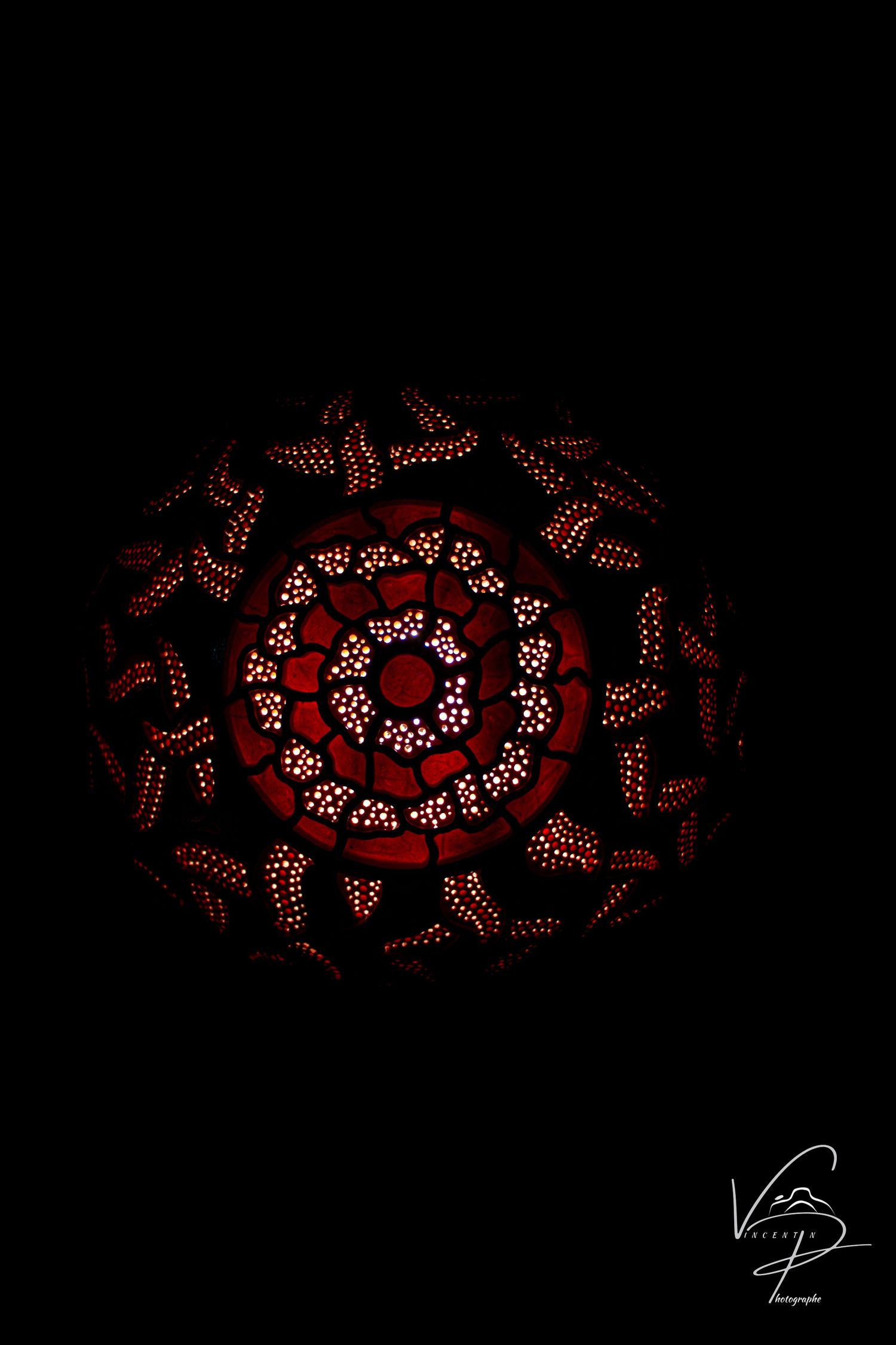 Spiral pattern of red LED lights creating abstract design in darkness.