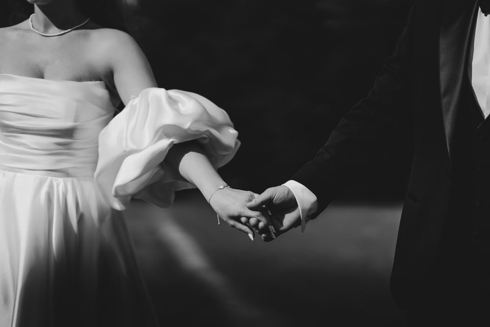 Black and white closeup of hands touching during a wedding ceremony.