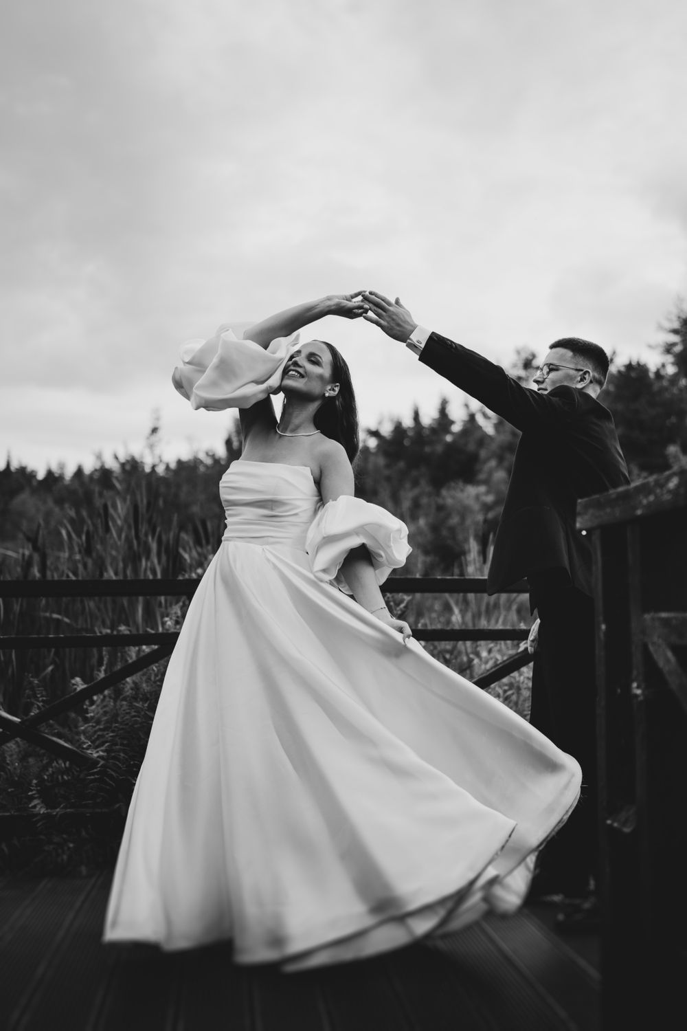 Bride twirls in flowing white dress while dancing with groom.