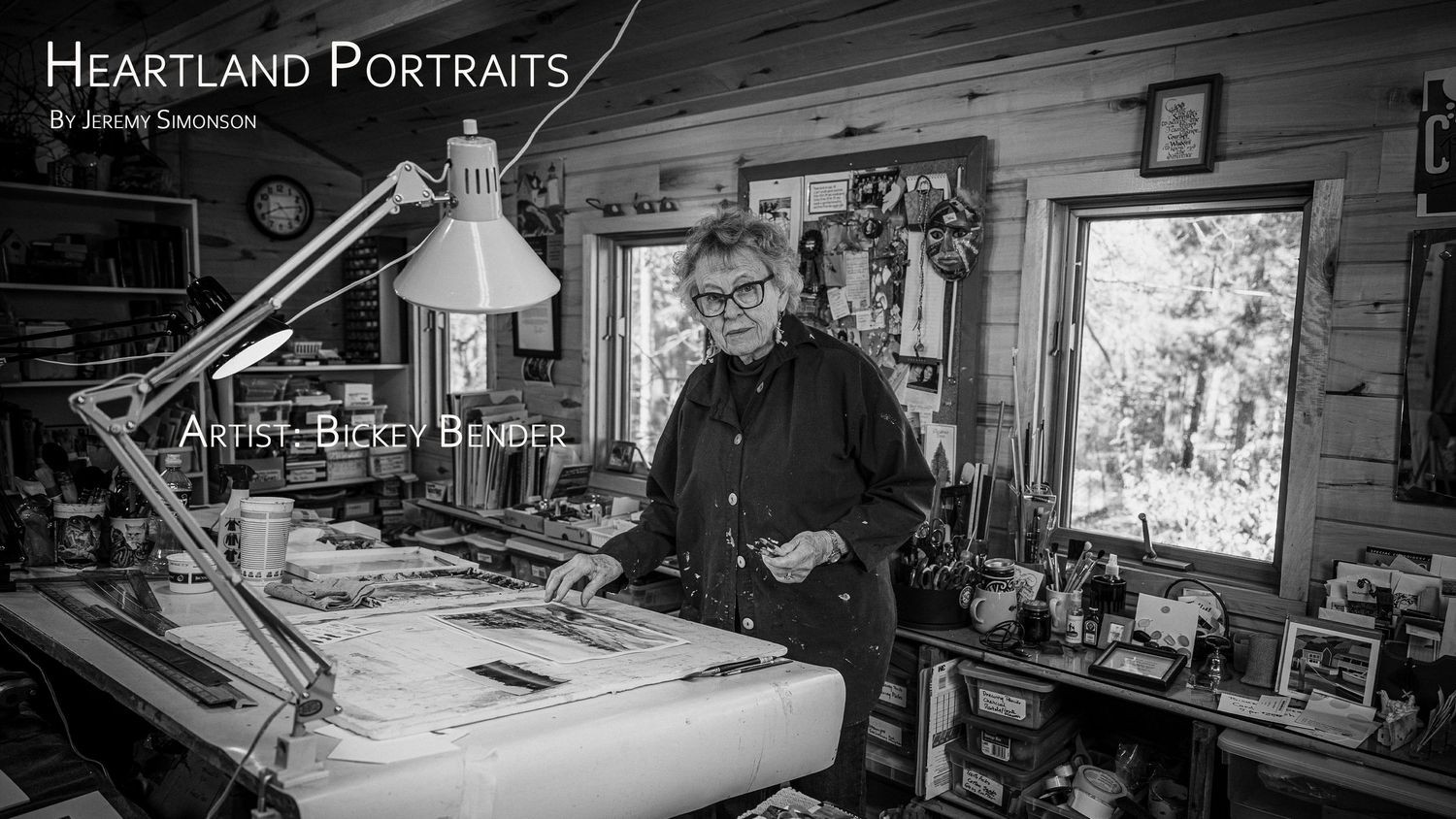 A black and white panoramic view shows multiple workstations in a photography studio with lighting equipment and props.