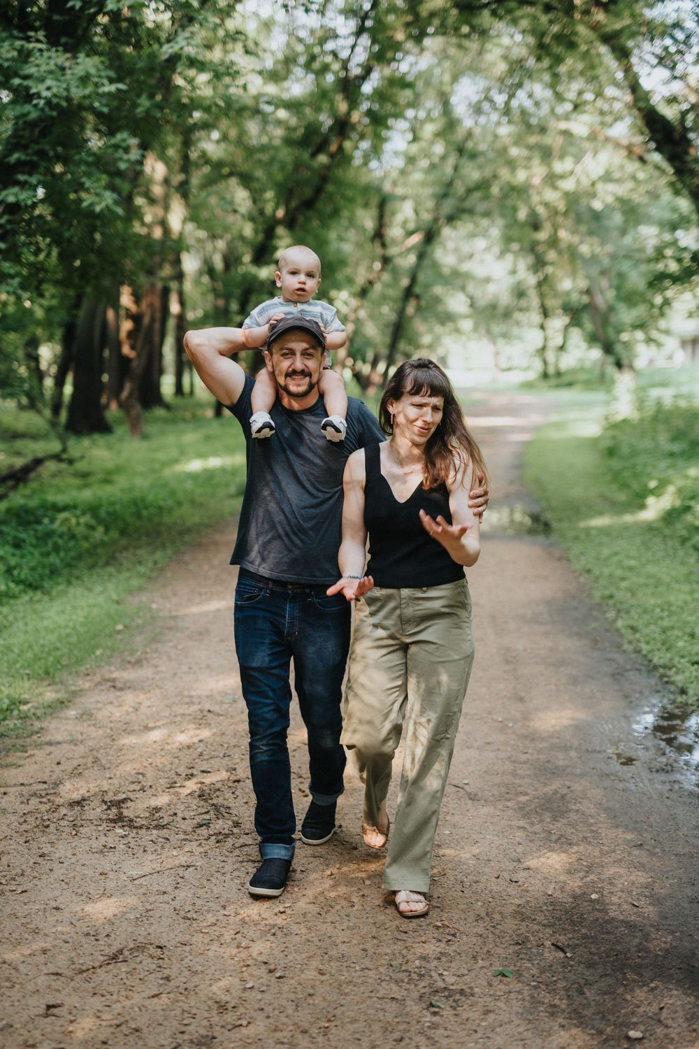 People walking together on a dirt path through lush green woods.