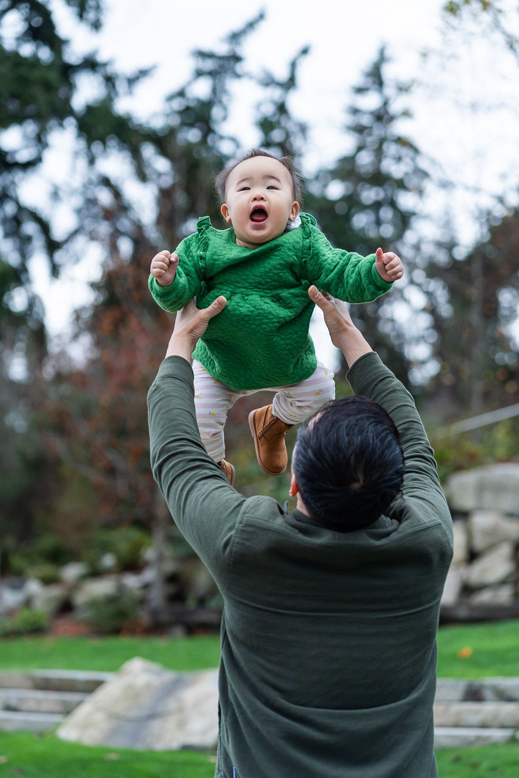 Dad throwing daughter into the air.
