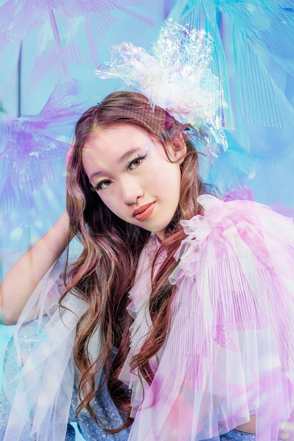 Ethereal portrait series with soft pink tulle and dreamy blue background creating a romantic fairytale aesthetic.