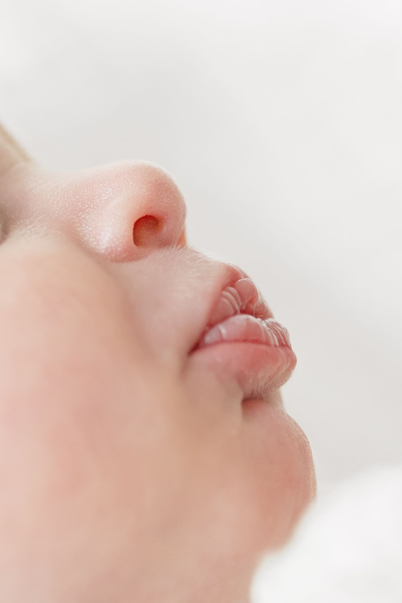 Close-up profile view of a nose and lips against a white background.