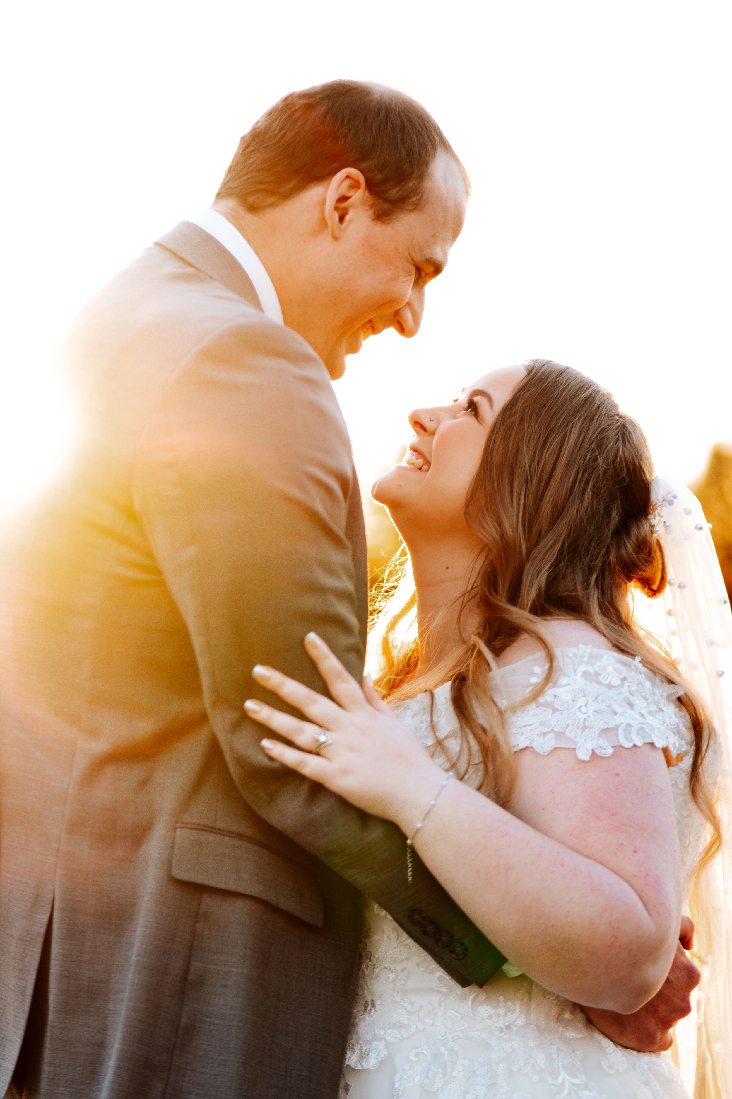 A romantic sunset silhouette of a couple embracing during their wedding photoshoot.