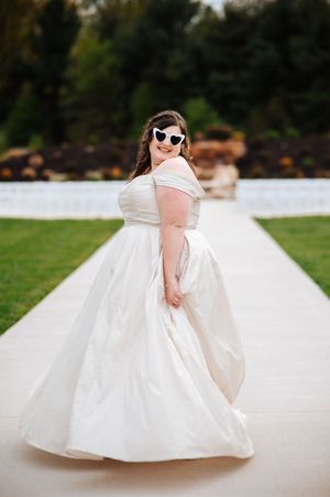 A bride in a flowing white ballgown twirls gracefully in a series of photos showing the dress's movement and elegance at Birchwood Meadows.