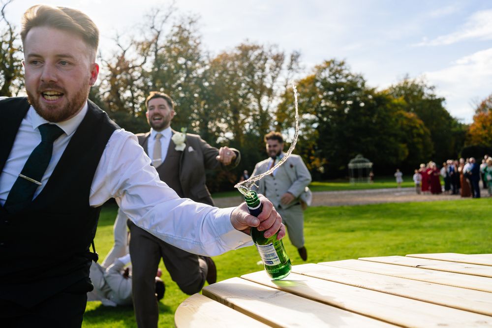 Playful outdoor wedding moment with guests enjoying lawn games at a garden reception.