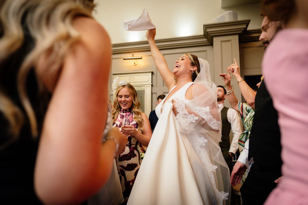 Joyful celebration moment during wedding reception with guests in elegant indoor setting.