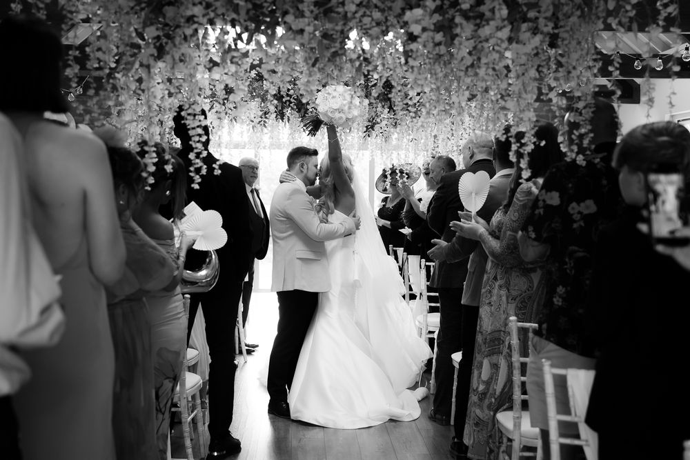 Black and white wedding ceremony photos showing guests and celebrations in an intimate setting.