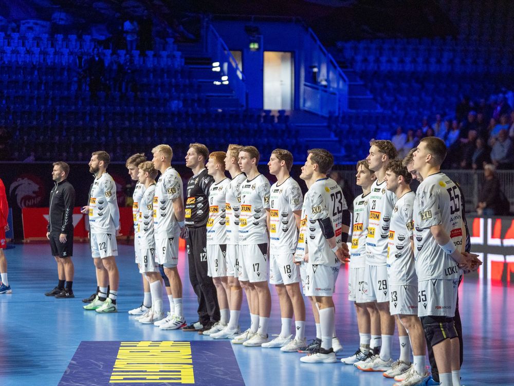 Sports team lined up on a blue court during pre-game ceremonies.